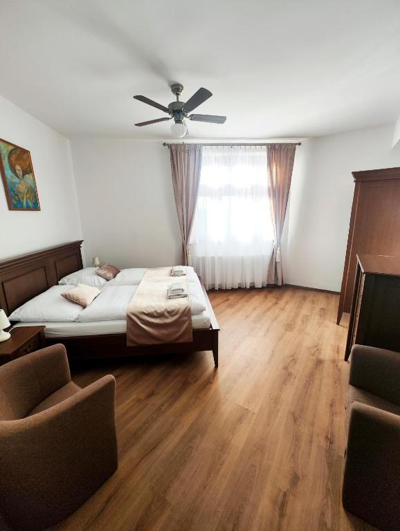 a bedroom with a bed and a ceiling fan at Smolenický zámok in Smolenice