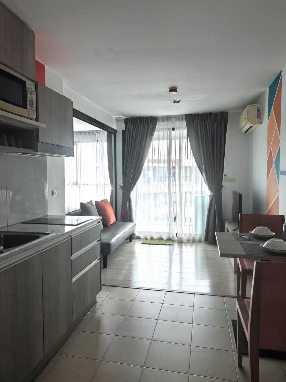 a kitchen and living room with a couch and a table at Centrio phuket 07 in Ban Rangeng