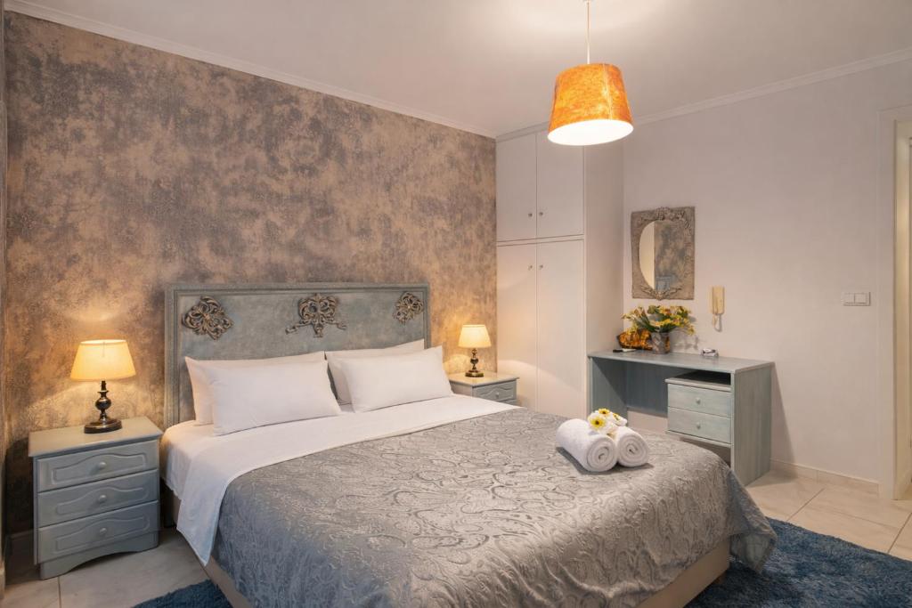 a bedroom with a large bed with two towels at Art Suites Mesologgi in Missolonghi