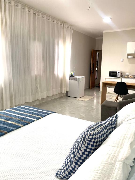 a bedroom with a bed and a living room at Studio Aconchegante e Moderno in Castanhal