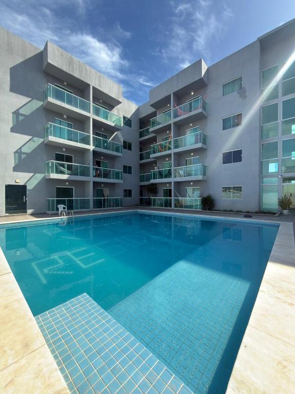 a large swimming pool in front of a building at Maragogi Peroba Ville Residence in Maragogi