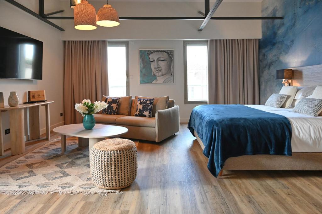 a hotel room with a bed and a couch at Walnut Bistro & Suites in Eymet