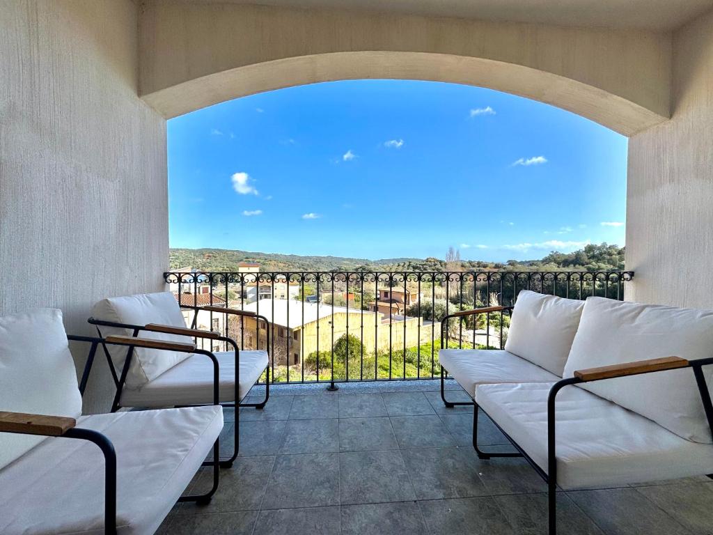 a balcony with white couches and a large window at Skyline Terrace in Loceri