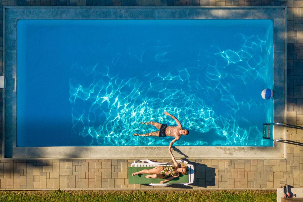 a woman is swimming in a swimming pool at Anna Vendégház Szilvásvárad in Szilvásvárad