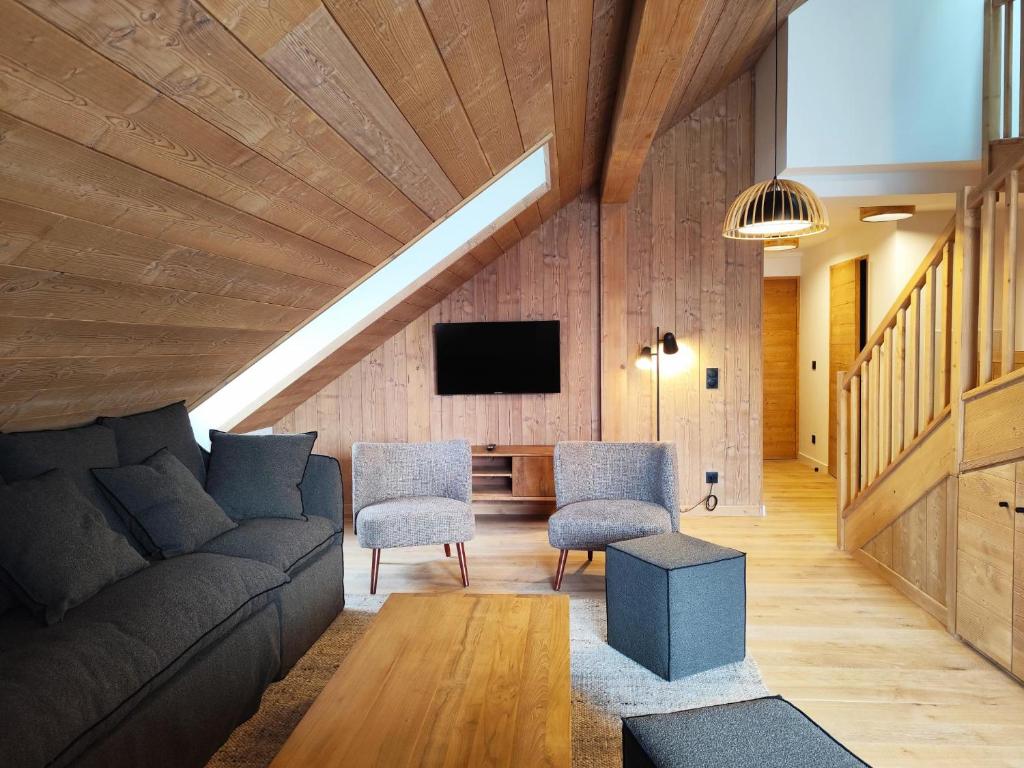 a living room with a couch and chairs and a tv at La Source in Saint-Gervais-les-Bains