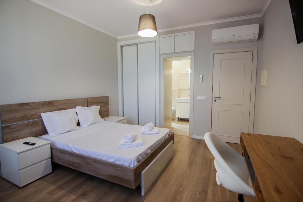 a bedroom with a bed and a desk and a table at QUANICE - Relaxing Guest House in Faro in Faro