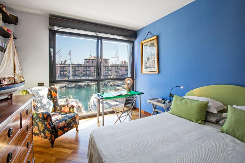 a bedroom with a bed and a desk and a window at Sull'Acqua del Porto Antico in Genoa