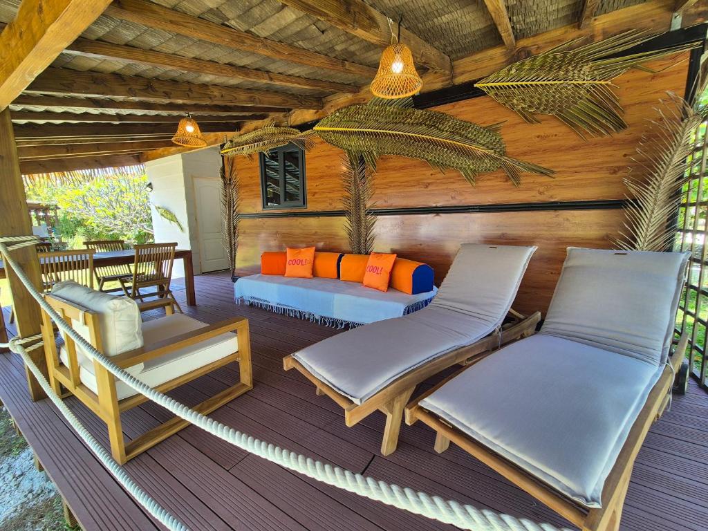 a porch with two chairs and a hammock at Rangiroa Tiny House - Tiaré le cocoon in Tiputa