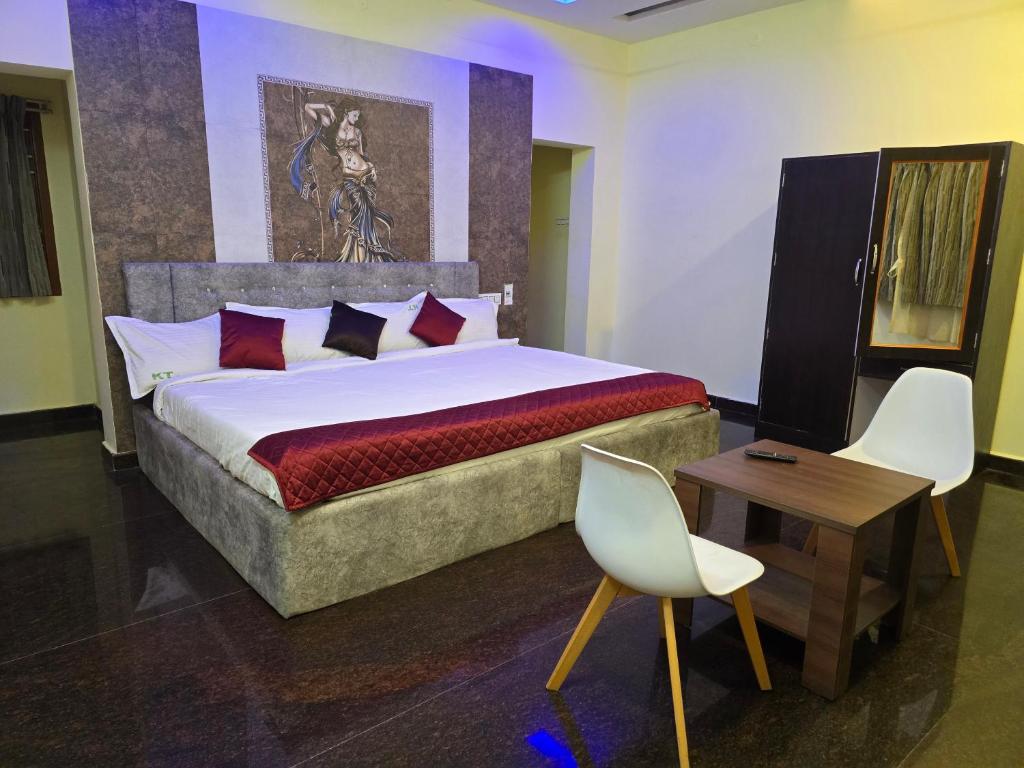a bedroom with a large bed and a table and chairs at Yercaud Misty Haven in Yercaud