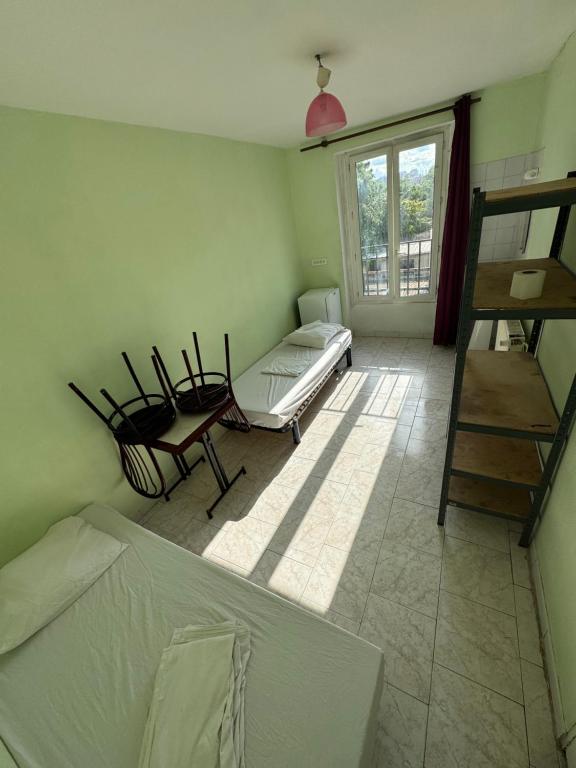 a room with a bed and a window and a ladder at Hostel Wilson in Saint-Denis