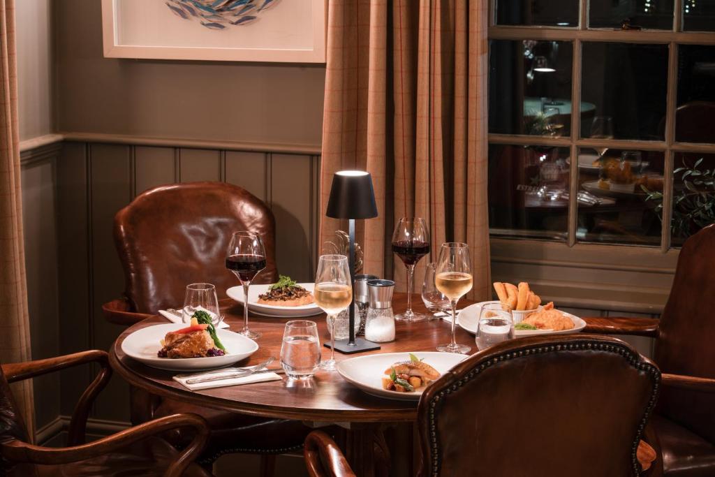 a table with plates of food and glasses of wine at Flower Pot Hotel in Henley on Thames