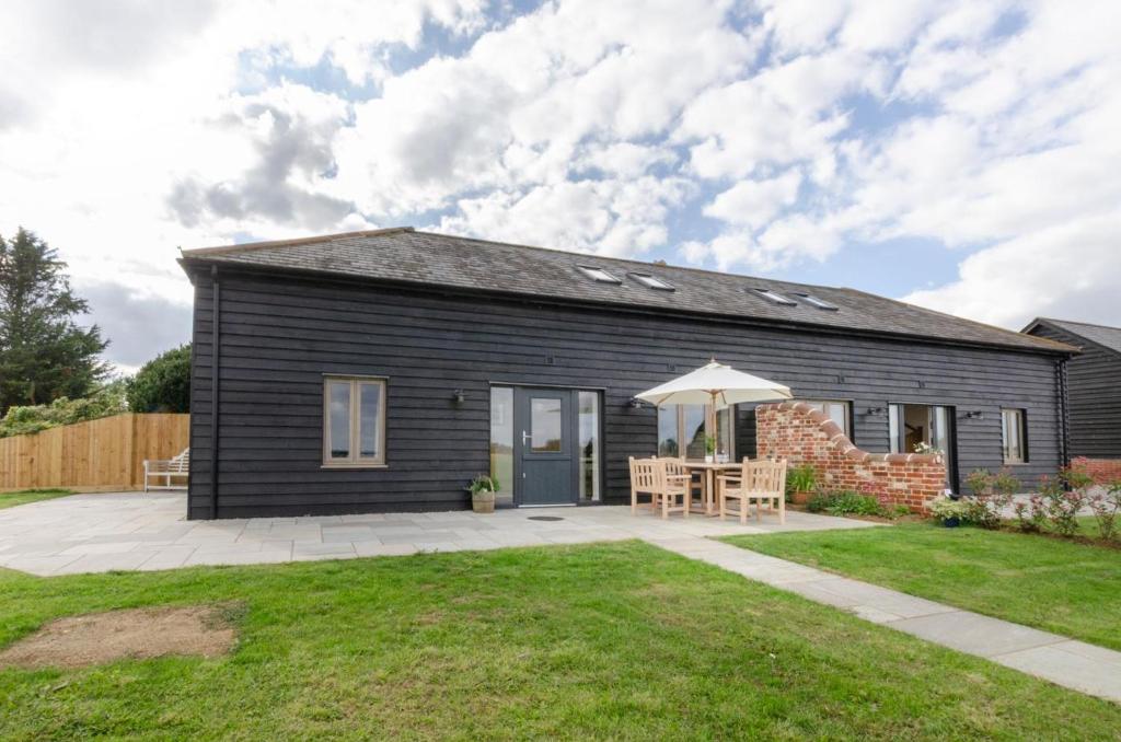 a black house with a patio and an umbrella at 2 Bed in Newton oc-ffba in Newton