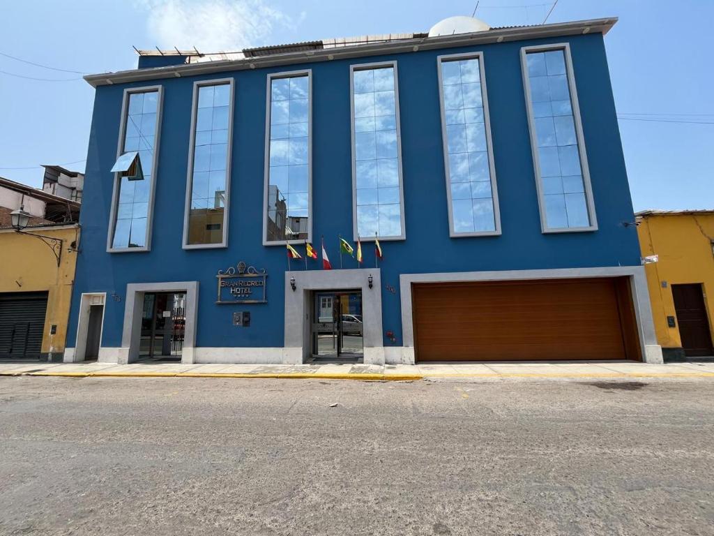 a blue building with a garage in front of it at Gran Recreo Hotel - Trujillo - Perú in Trujillo