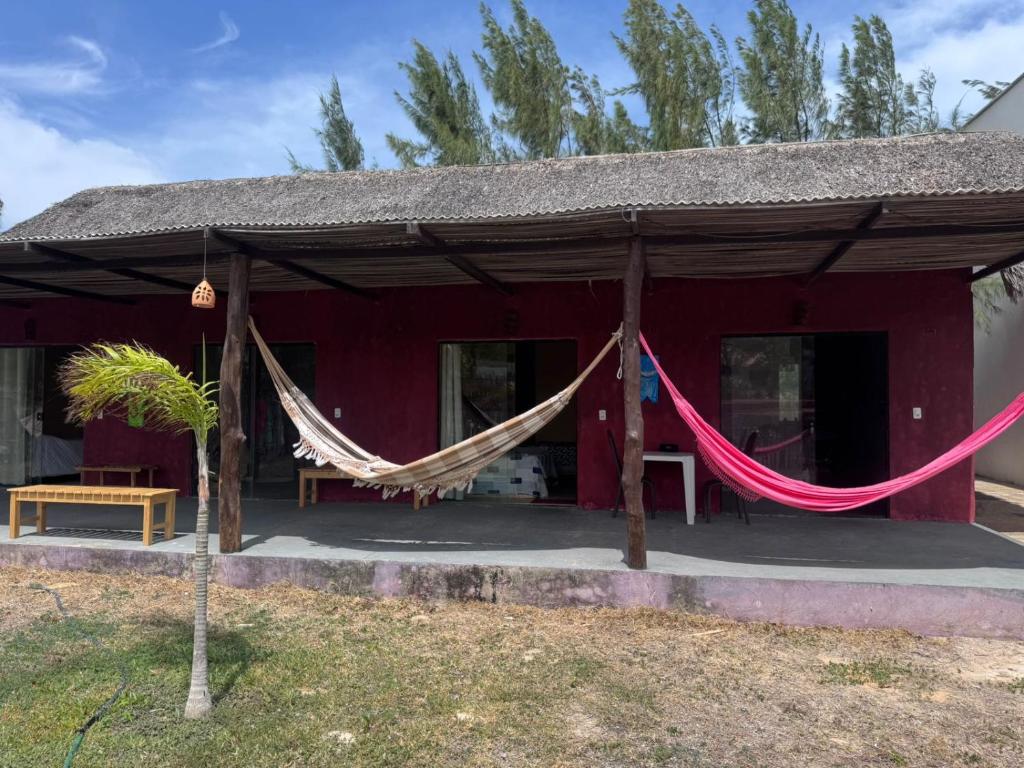 a red house with hammocks in front of it at Vila Macapaz Kitesurf in Luis Correia