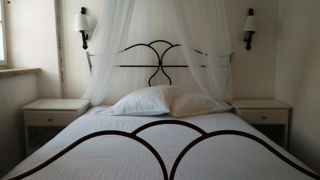 a bedroom with a black and white bed with two tables at Stone House Petra in Perast