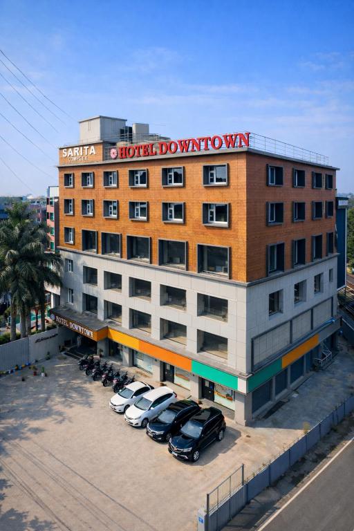 a hotel building with cars parked in a parking lot at Hotel Downtown in Jamshedpur