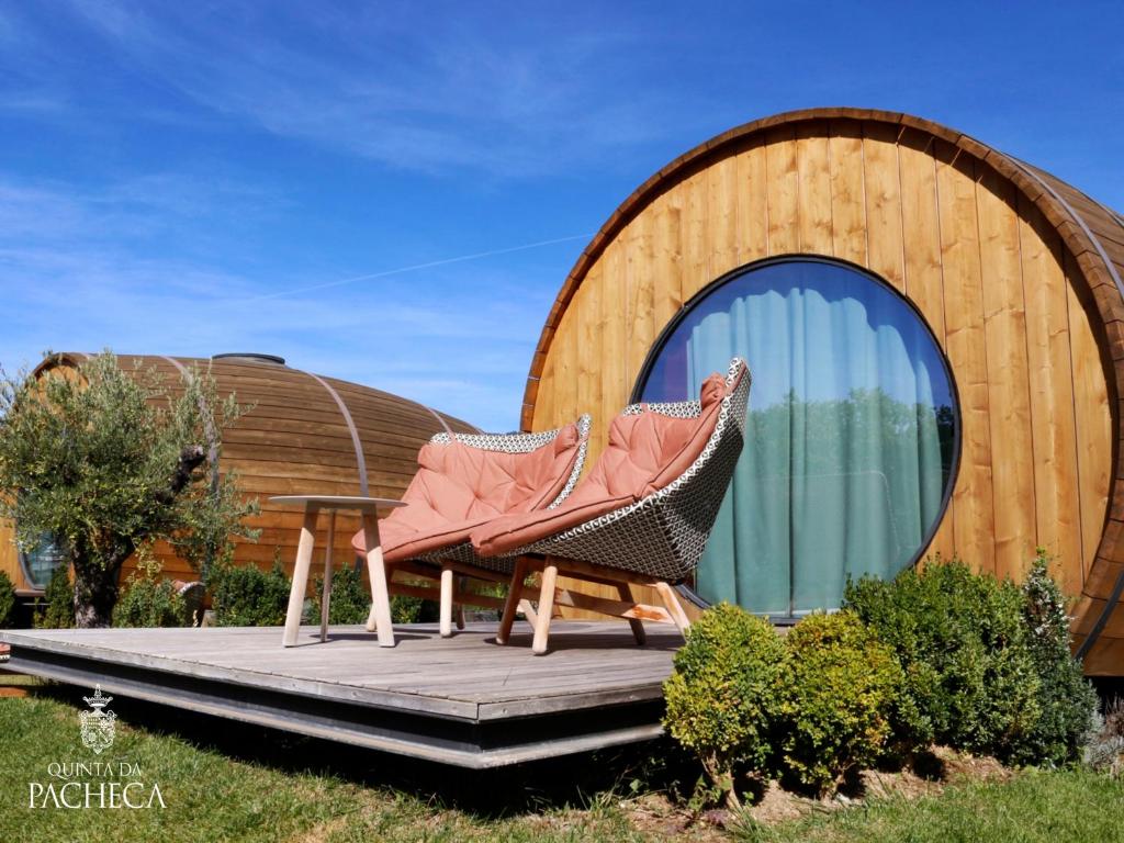 a couple of chairs sitting on a deck in front of a building at Pacheca The Wine House Hotel e Spa - Quinta da Pacheca in Lamego