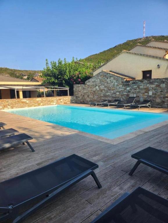a large swimming pool with chairs and a building at I Bugni in Sisco