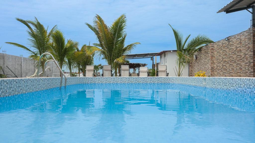a blue swimming pool with palm trees in the background at Amarena Resorts in Bocapán