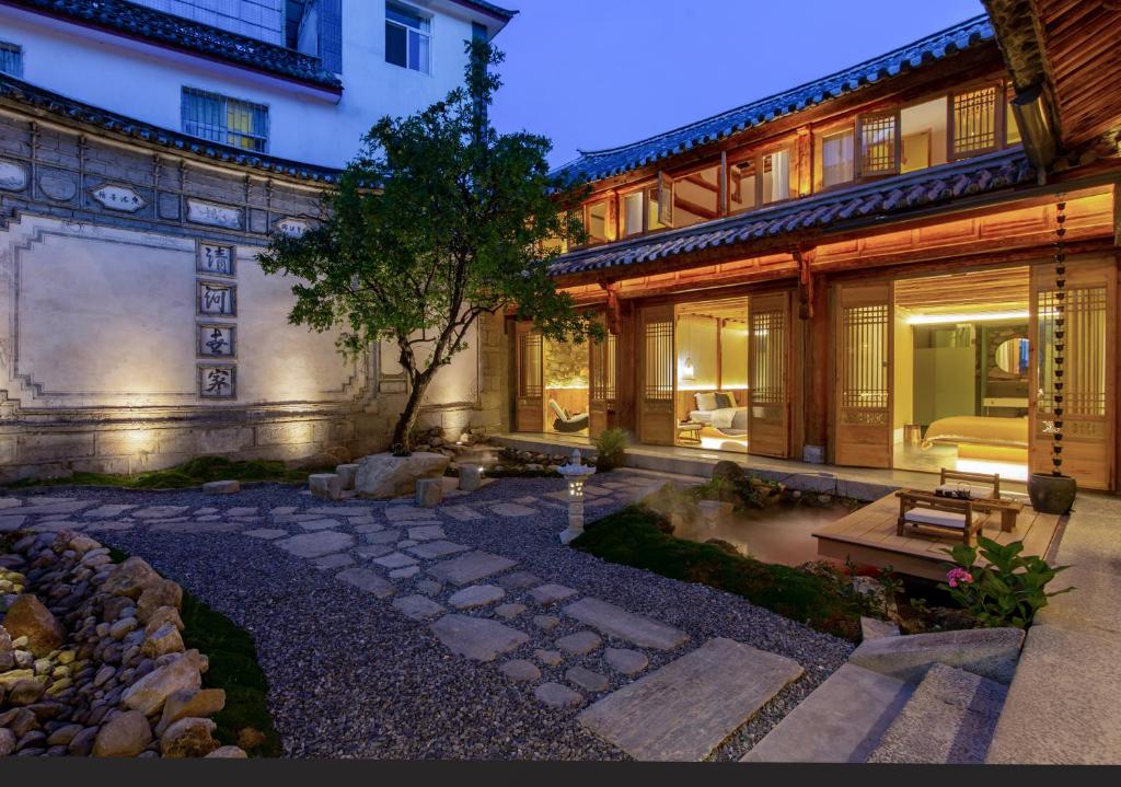 a house with a courtyard with a bench and a tree at 心墅 空间 in Dali