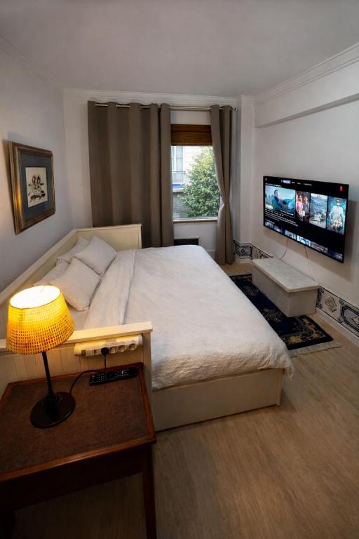 a bedroom with a large bed and a television at Double Room near Lisbon & Sintra in Queluz