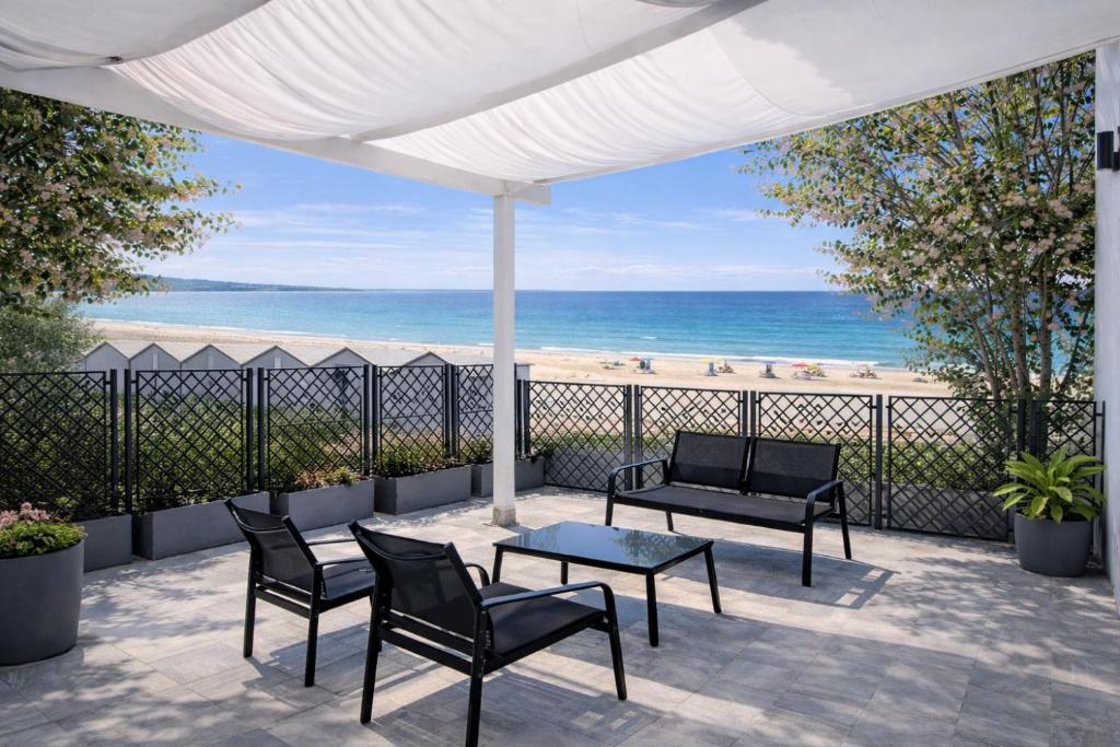 a patio with a table and chairs and the beach at Marco House - Seaview Apartment - Fronte Mare - Case Vacanza Anzio in Anzio