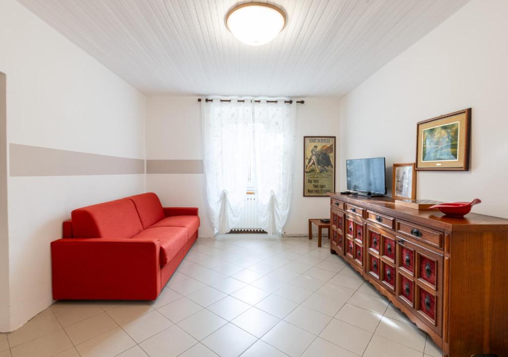 a living room with a red couch and a television at Casa di Montagna tranquilla e spaziosa in Serina
