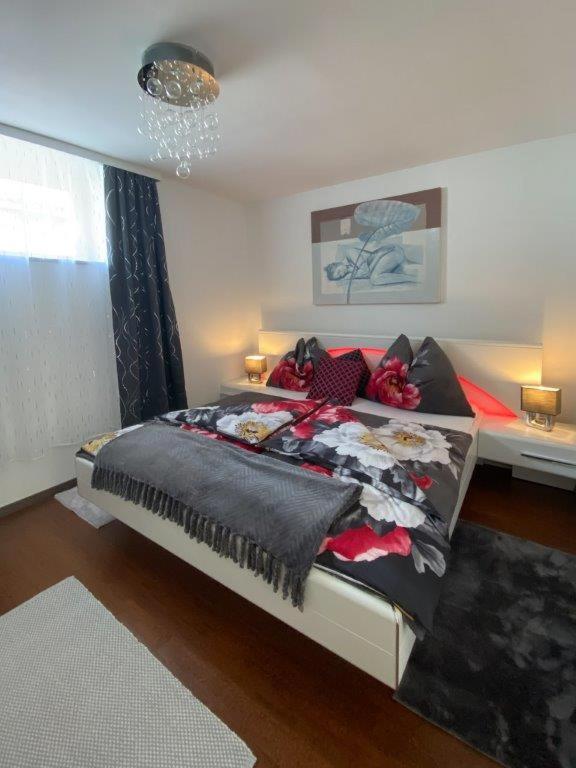 a bedroom with a large bed with black and red pillows at Klein und Fein in Hartberg