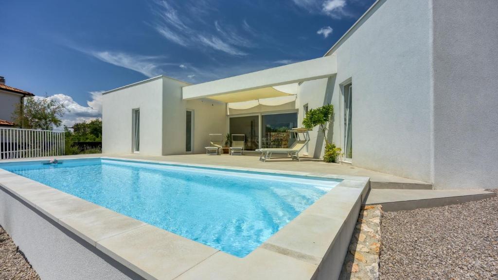 a swimming pool in front of a house at Villa Menta 4 by Villas Guide in Malinska