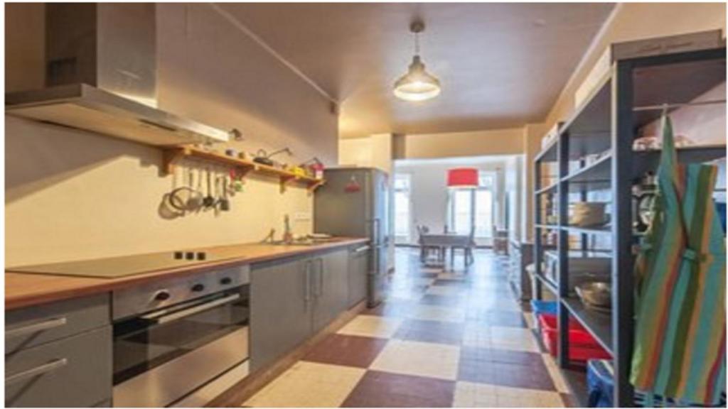 a kitchen with stainless steel appliances and a tile floor at Chez Georges in Carcassonne