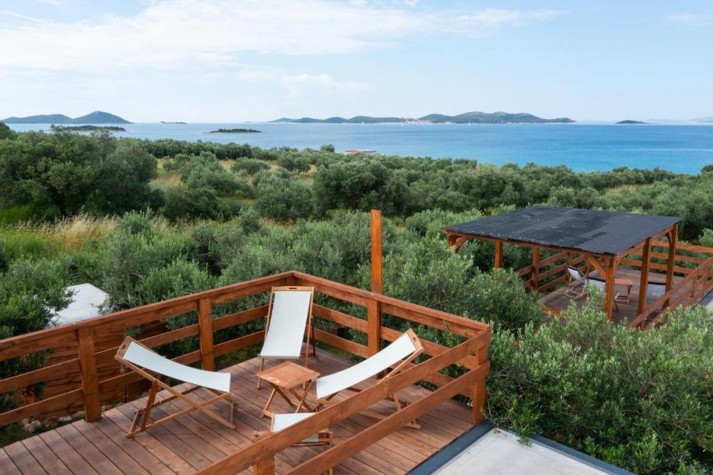 a deck with two chairs and a gazebo at House no 1 in Pakoštane