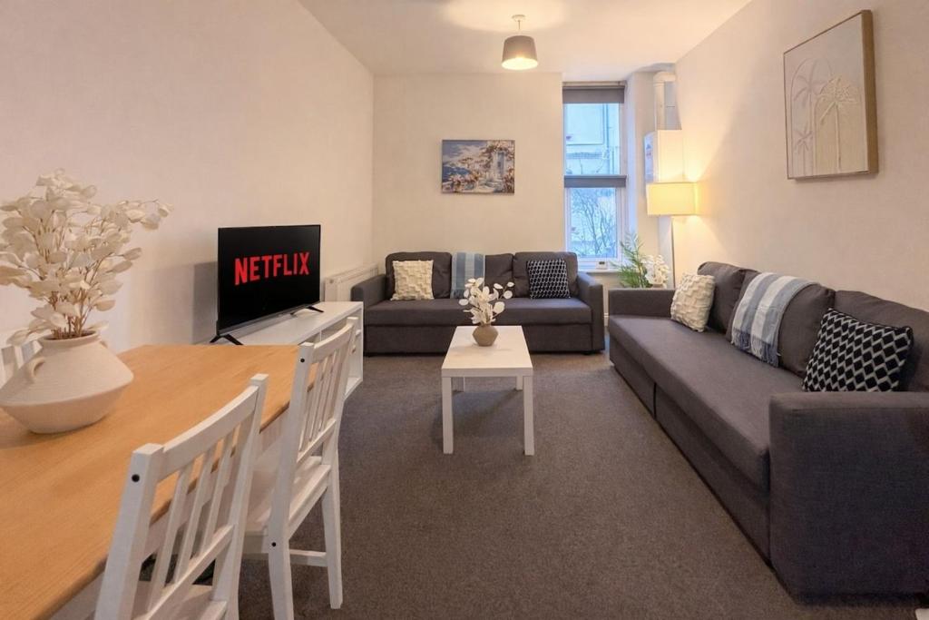 a living room with a couch and a table at Euston Road - Beach Apartment 9 in Great Yarmouth