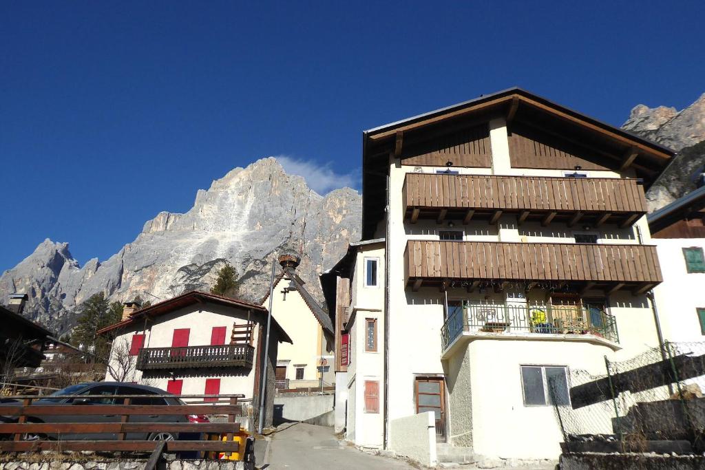a building with a balcony with a mountain in the background at Casa Tomà Mountain View Cortina in San Vito di Cadore