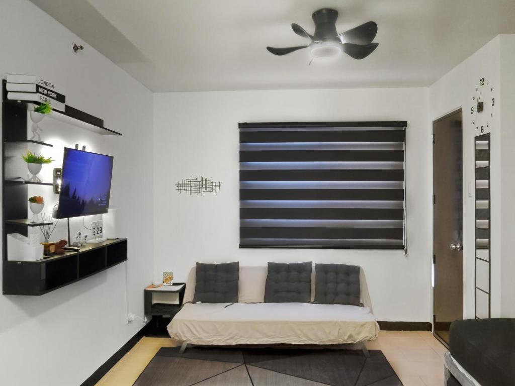 a living room with a bed and a ceiling fan at LunaVista in Bankal
