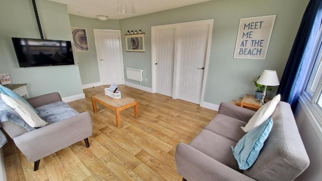 a living room with two couches and a table at 7 The Burrows in Braunton