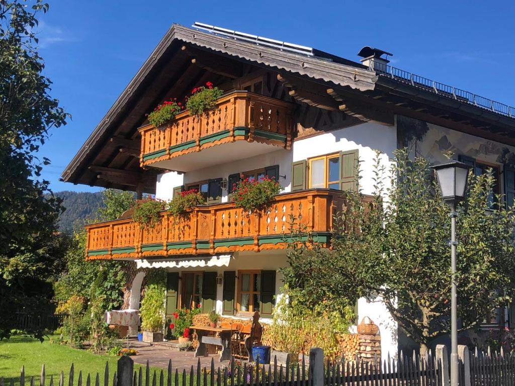 a building with a balcony with flowers on it at Landhaus Elisabeth in Krün