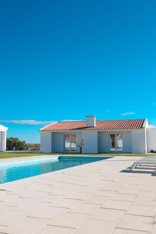 a villa with a swimming pool and a house at Casa Cabeça in Macedo de Cavaleiros