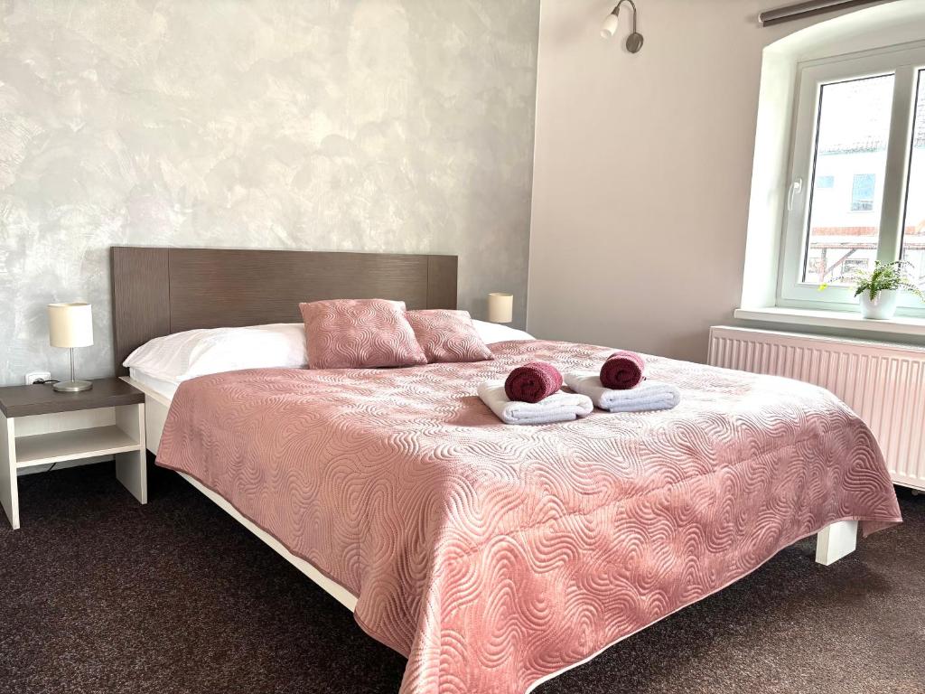 a bedroom with a bed with two towels on it at Penzion Sen in Černá v Pošumaví