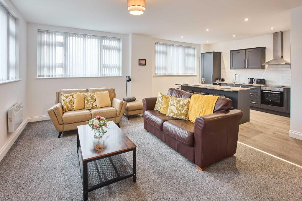 a living room with two couches and a kitchen at Host & Stay - Promenade Suite in Blackpool