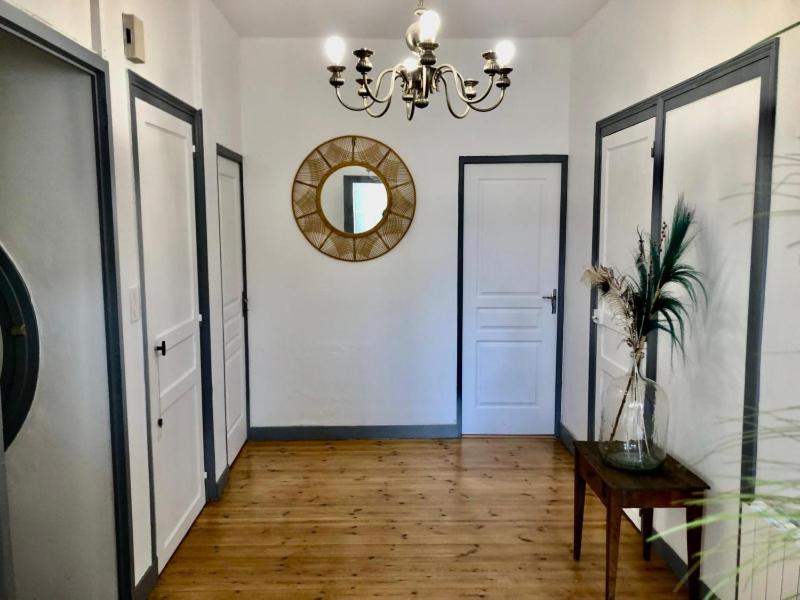 a hallway with a table and a mirror and doors at Centre ville 38 Maréchaux in Saint-Jean-dʼAngély