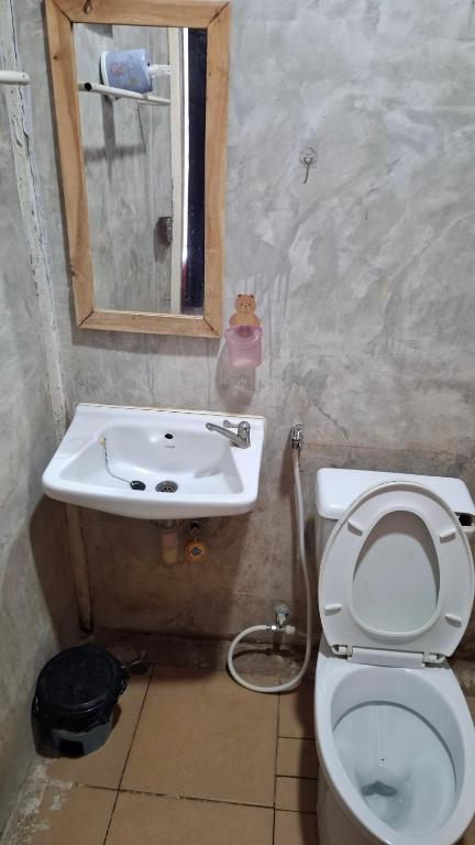a bathroom with a toilet and a sink at เฮือนอุ้ยดี2 in Ban Khua Nam Chun
