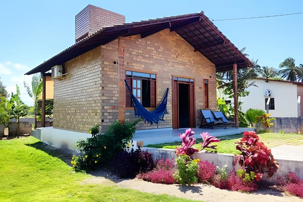 a brick house with a swimming pool in a yard at Bella Casa Bougainville - APA Barra de Mamanguape in Rio Tinto