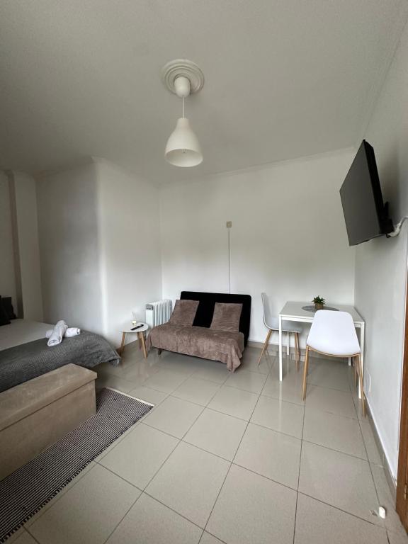 a room with a bed and a table and a couch at Apartamento cerca de la playa 8 in Vigo