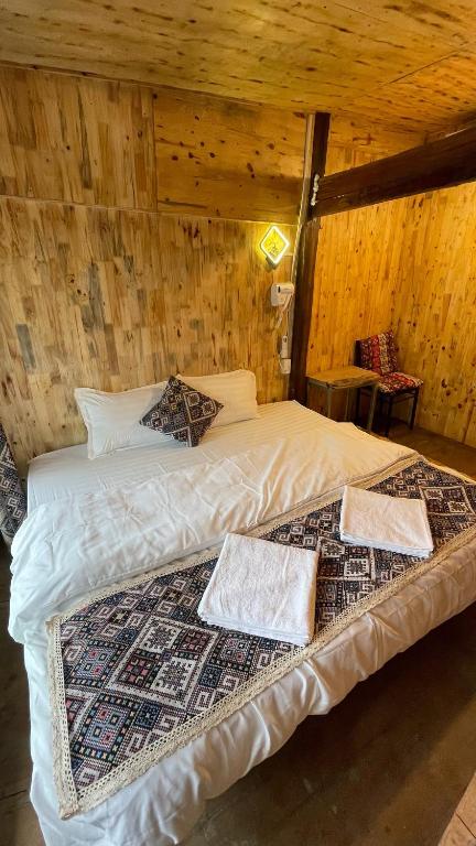 a bed in a wooden room with two pillows on it at Km 0 home Du Già in Muong Cha