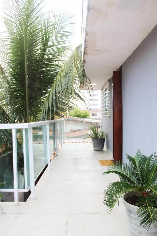 a hallway with palm trees on a balcony at Duplex Apartamento em Casa Caiada in Olinda