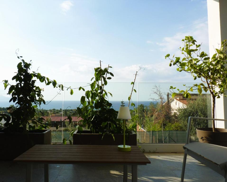 a patio with a wooden table and plants on a balcony at AmarMare Bed&Breakfast in Trappeto