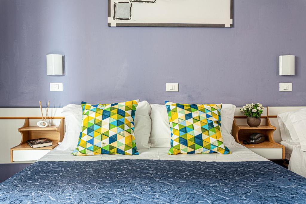 a bedroom with a bed with colorful pillows at Hotel Solaris in Gatteo a Mare