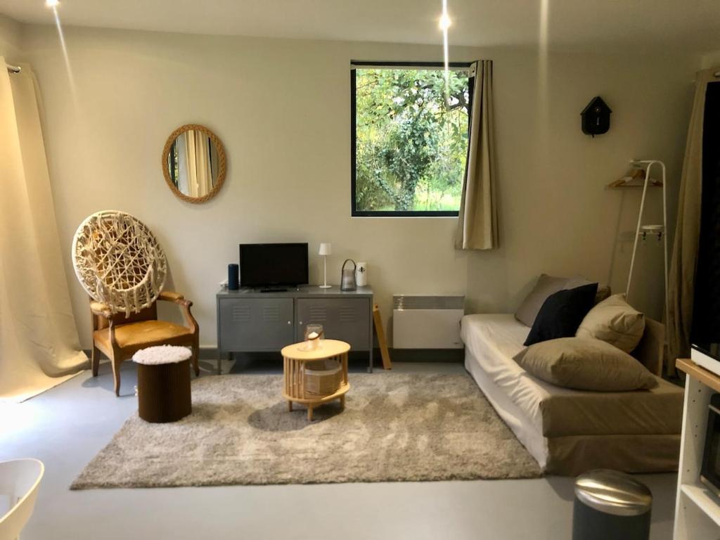 a living room with a couch and a table at Au Passe-Temps in Mettray