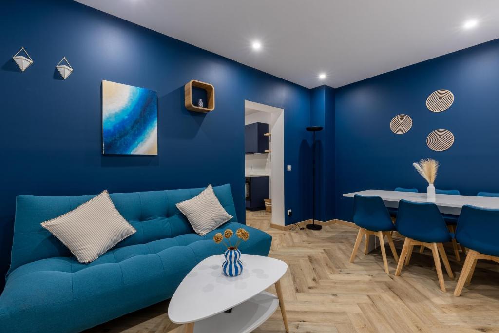 a blue living room with a blue couch and a table at La Perle Bleue in Algrange