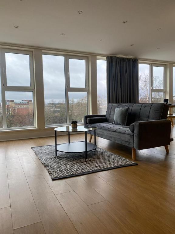 a living room with a couch and a table at Newcastle City Penthouse in Newcastle upon Tyne
